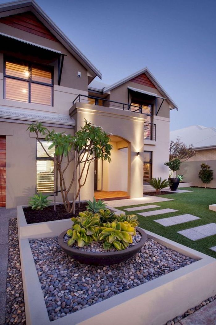 gravel and grass in front of two storey house front of house landscaping tiled pathway leading to the front door