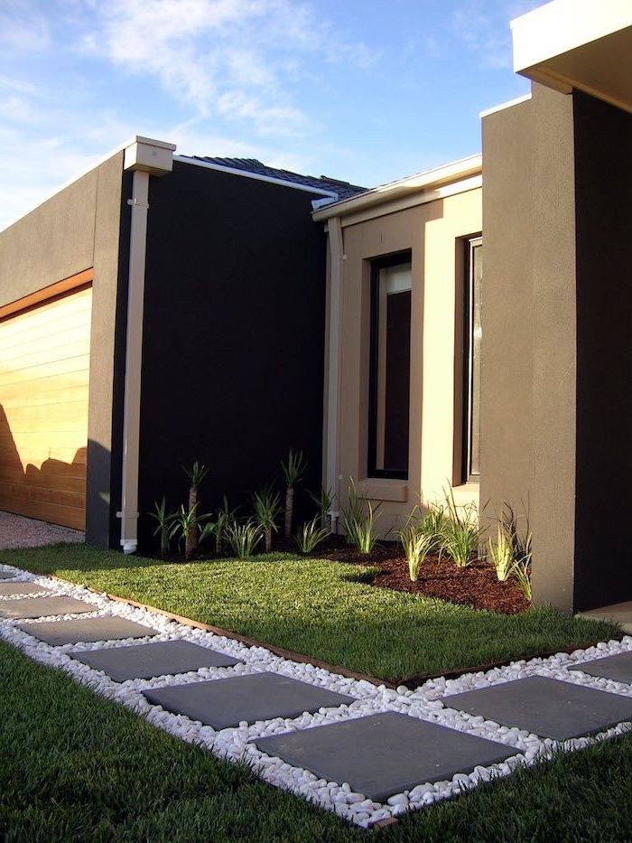 gravel with tiles pathway surrounded by grass low maintenance landscaping ideas small bushes palms planted in front of one storey house