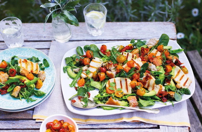 grilled halloumi cheese with spinach halved cherry tomatoes cucumbers easy salad recipes white plate on wooden table
