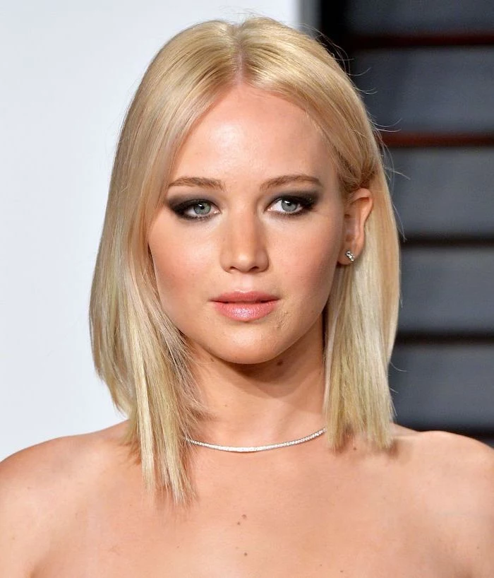 jennifer lawrence on the red carpet with straightened blonde hair separated in the middle short haircuts for fine hair wearing diamond necklace
