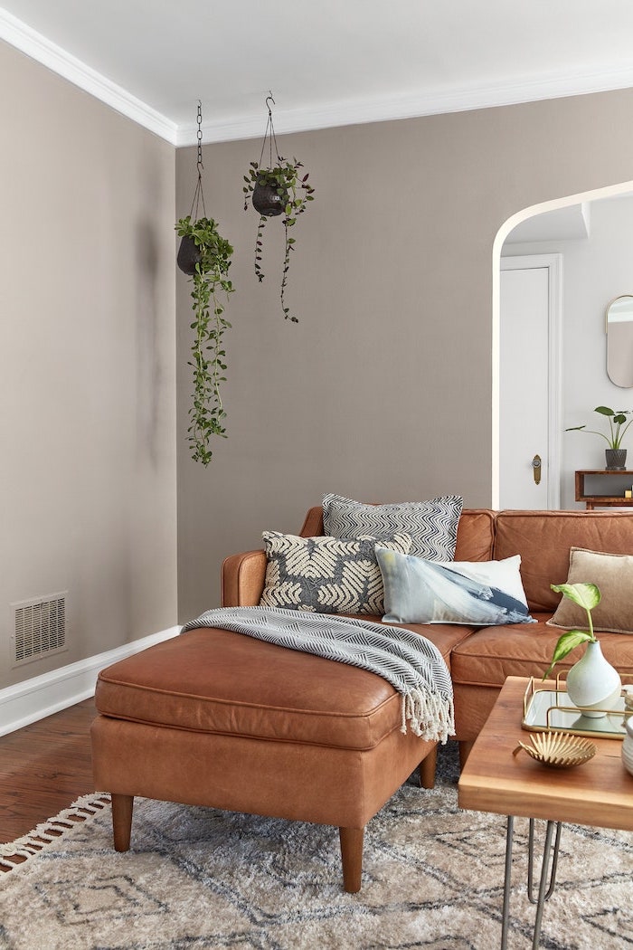 living room paint color ideas brown leather corner sofa with blue white and black throw pillows light gray walls wooden floor