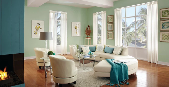 living room wall colors light mint green walls with tall windows white sofa with turquoise white throw pillows white armchairs wooden floor
