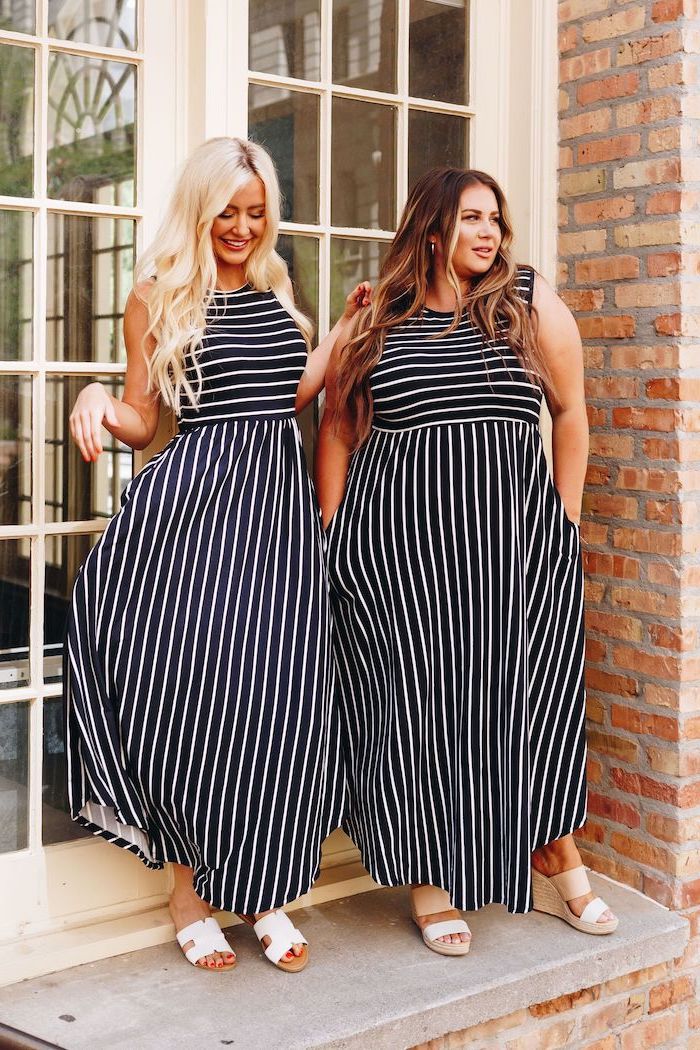 long summer dresses two women blonde and brunette wearing identical long dresses black with white stripes white sandals