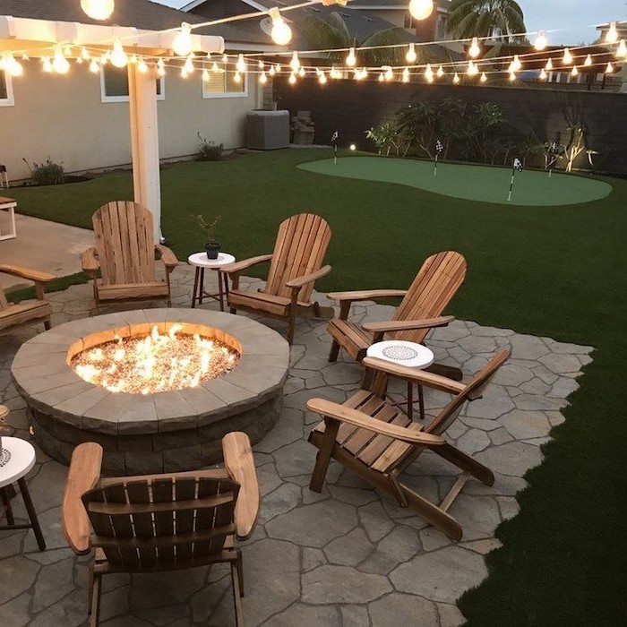 mini golf course backyard landscaping ideas fire pit made of stones wooden lounge chairs arranged around it
