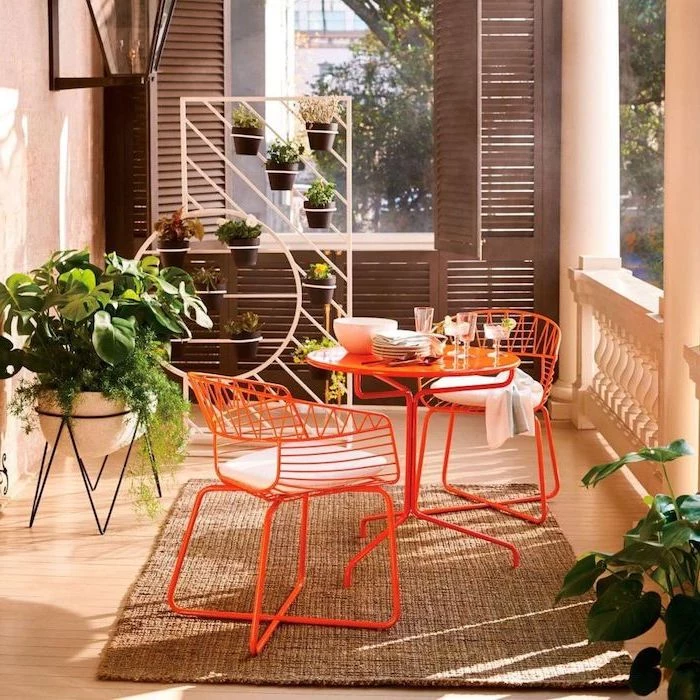 orange metal table with two chairs on grey carpet small patio ideas wooden floor lots of plants brown wooden blinds