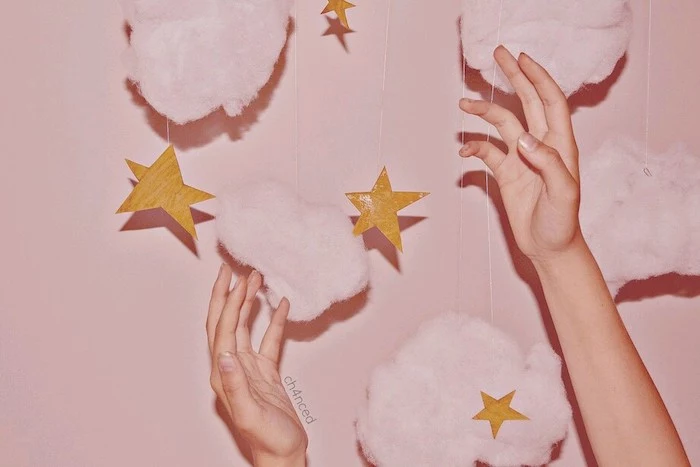 pink cotton clouds gold carton stars on strings hanging on pink wall cute wallpapers for girls