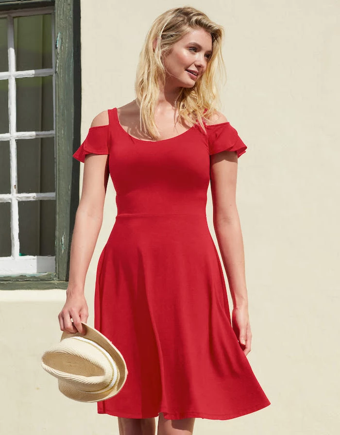 red dress worn by woman with short wavy blonde hair summer beach dresses carrying a hat