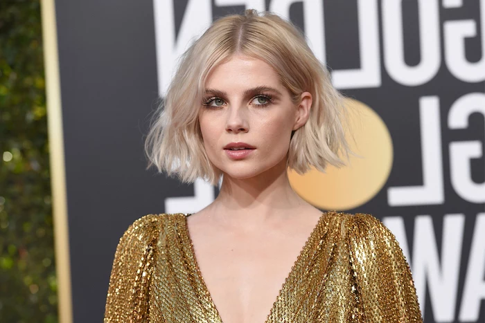 short hairstyles for thin hair lucy boynton on the red carpet wearing golden dress with short blonde hair with slight curls