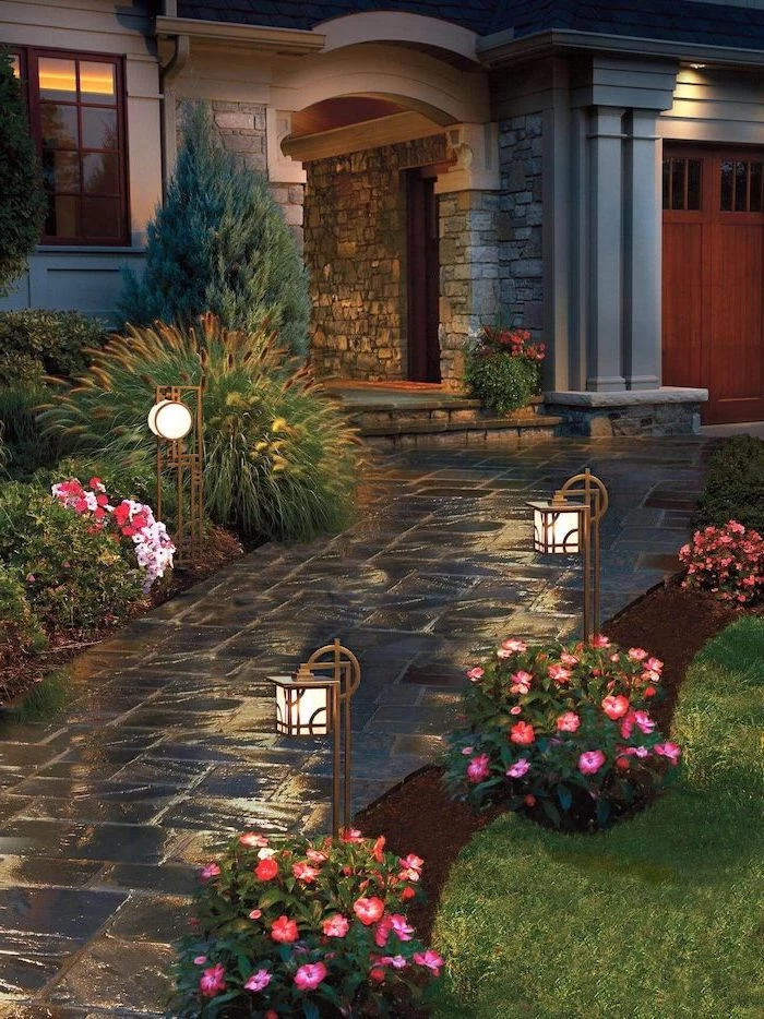 simple landscaping ideas stone tiled pathway leading to the front door flower beds bushes and garden lamps on both sides