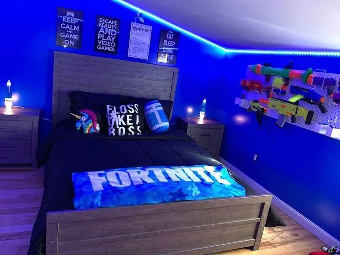 teen boy room ideas blue walls with led lights on top bed with fortnite blanket and gaming posters on the wall
