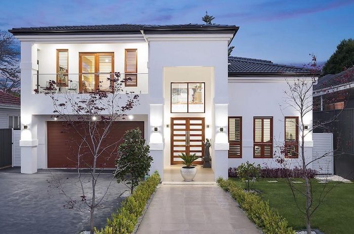 two storey house with tiled pathway leading to the front door small front yard landscaping ideas grass bushes and small trees on both sides