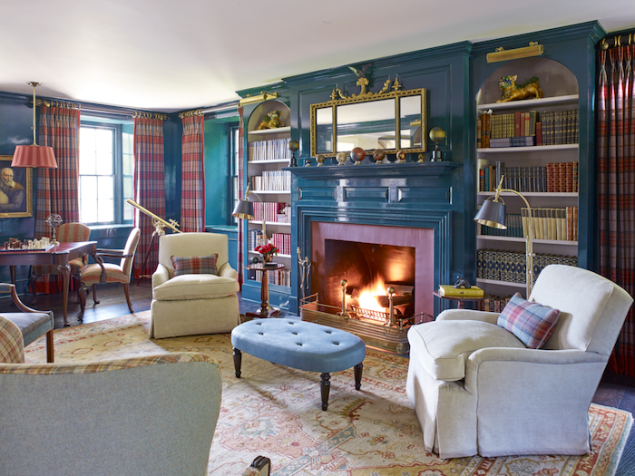 white armchairs blue ottoman in front of fireplace in purple living room color schemes blue walls colorful curtains