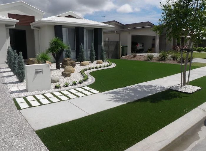 white one storey house cheap landscaping ideas grass and white tiles small gravel garden with bushes and small trees