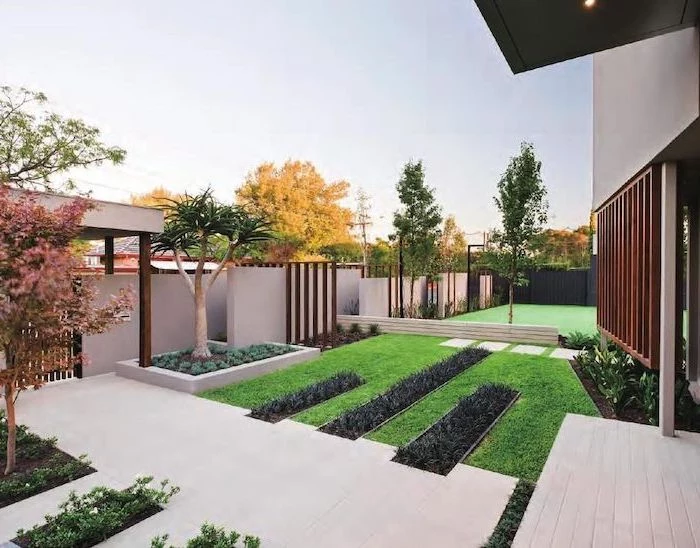 white tiled pathway surrounded by grass small front yard ideas small trees and flower beds on the sides