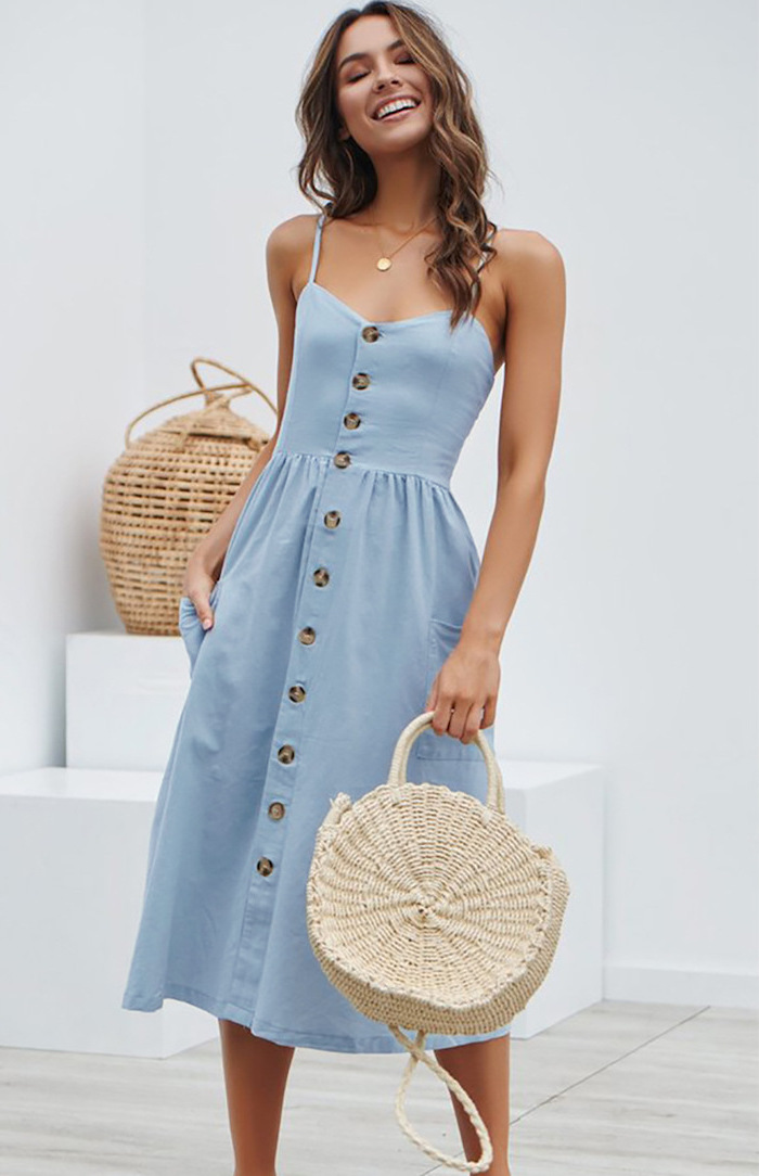 woman wearing blue midi dress with brown buttons flowy summer dresses with brown medium length wavy hair