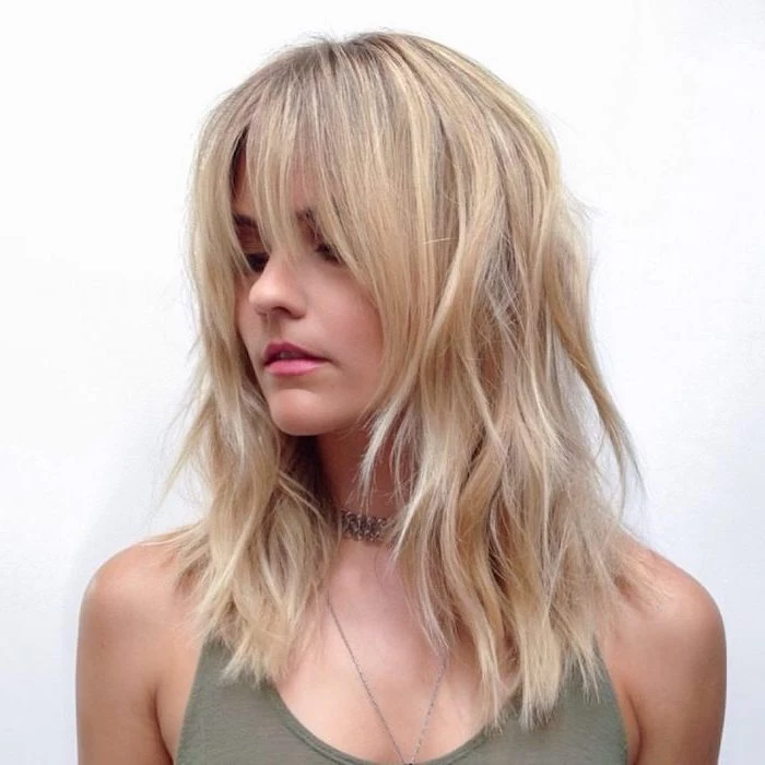 woman wearing green top short hairstyles for thin hair shoulder length blonde hair with highlights with bangs