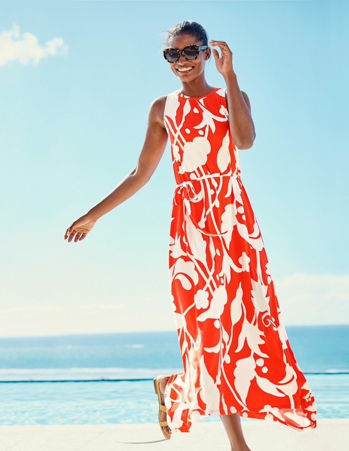 woman wearing long red dress with white flowers cotton summer dresses black hair in low updo sunglasses