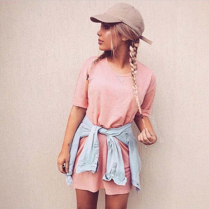 woman with blonde hair in two braids wearing pink t shirt dress summer maxi dresses denim jacket around her waist grey baseball cap