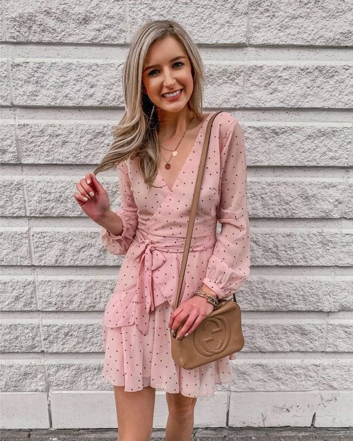 woman with blonde hair wearing pink dress with black dots cute summer dresses brown leather crossbody bag