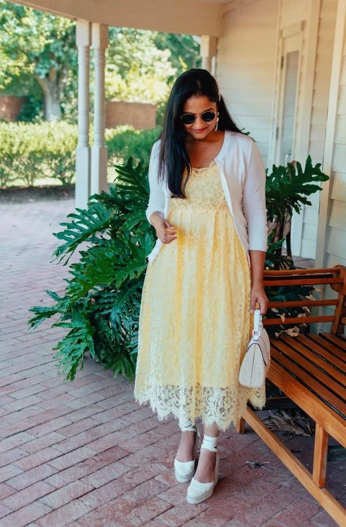 woman with long black hair wearing yellow lace midi dress white cardigan beautiful dresses to wear to a wedding white platform sandals bag