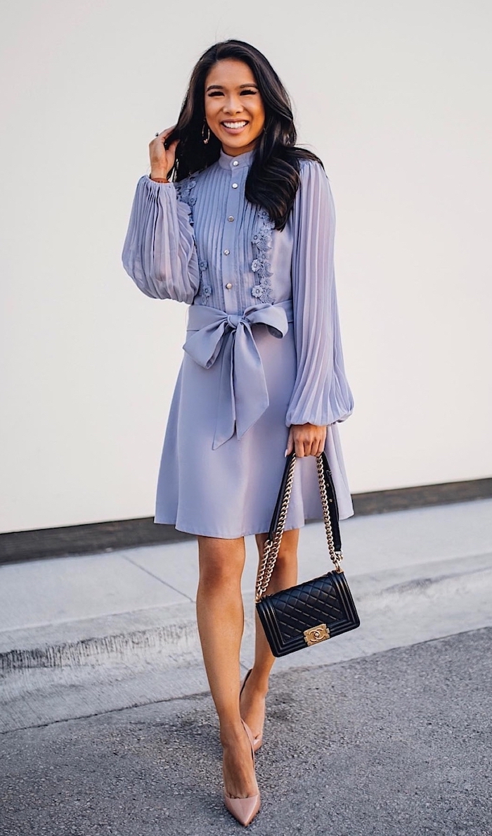 woman with wavy black hair wearing shirt purple dress with long pleated sleeves nude shoes black leather bag dresses to wear to a summer wedding