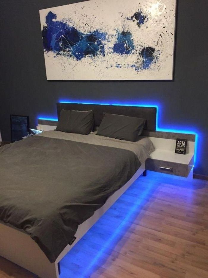 wooden floor boys room paint ideas twin bed with grey bed sheets blue led lights underneath blue white poster above the bed