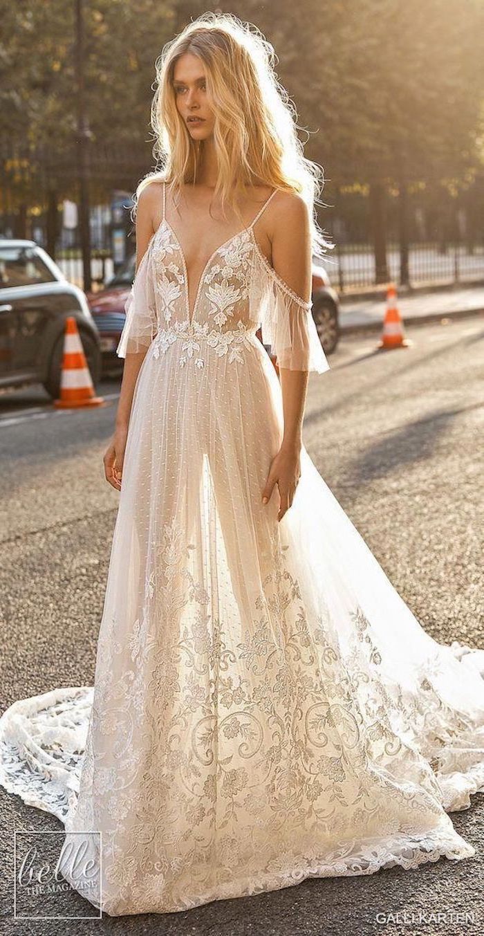 ball gown wedding dress woman with long blonde wavy hair walking down the street wearing dress made of tulle and lace