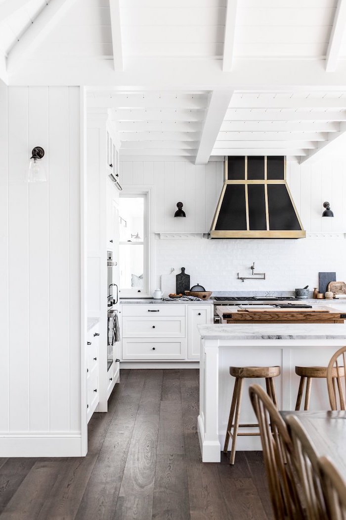 black accents on white walls rustic farmhouse kitchen white cabinets white kitchen island with marble countertop wooden bar stools