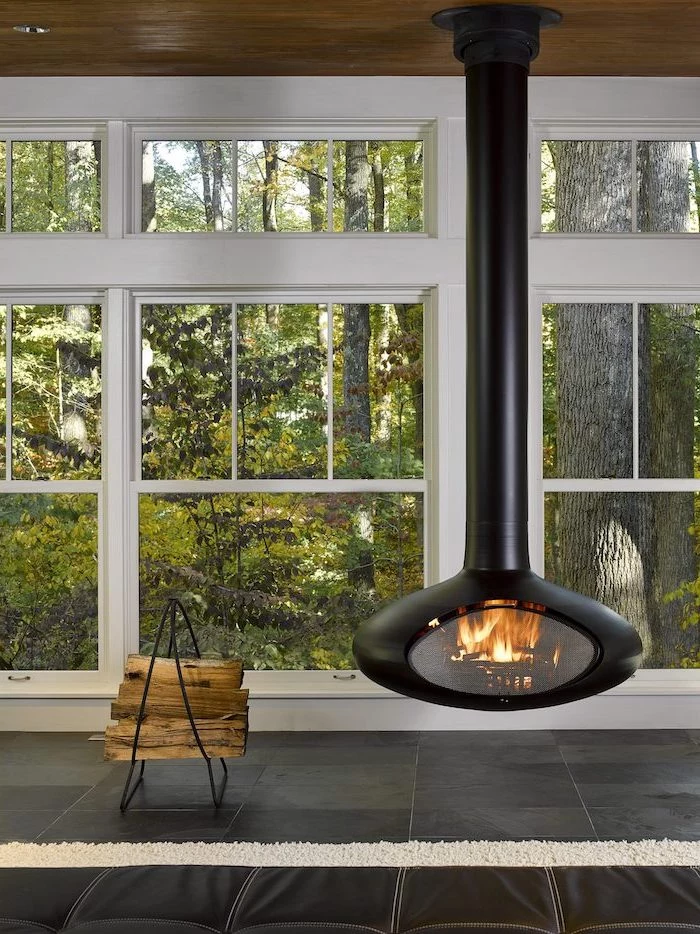 black fireplace hanging from the ceiling black tiled floor screened in back porch small stand for chopped wood on the side