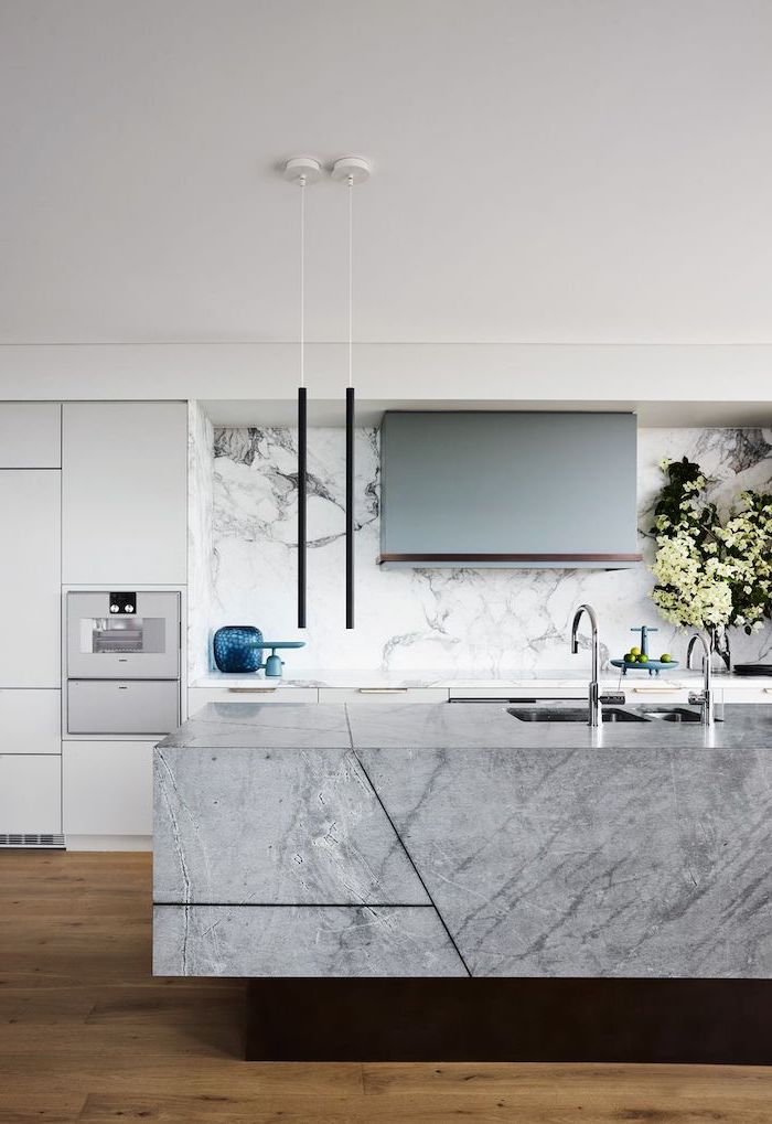 black pendants hanging from the ceiling above granite kitchen island subway tile backsplash marble backsplash white cabinets