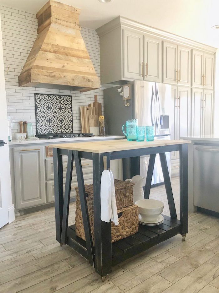 black wooden kitchen island farmhouse kitchen backsplash with white tiles light gray cabinets wooden floor