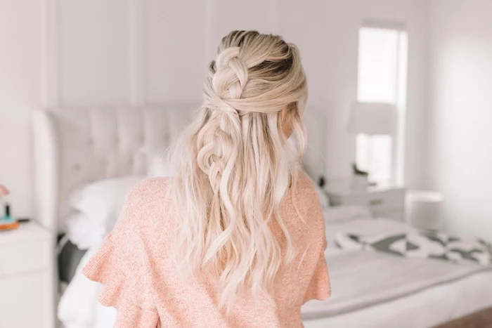 blonde woman with dark roots wearing pink blouse easy hairstyles for school half of her wavy hair in a braid