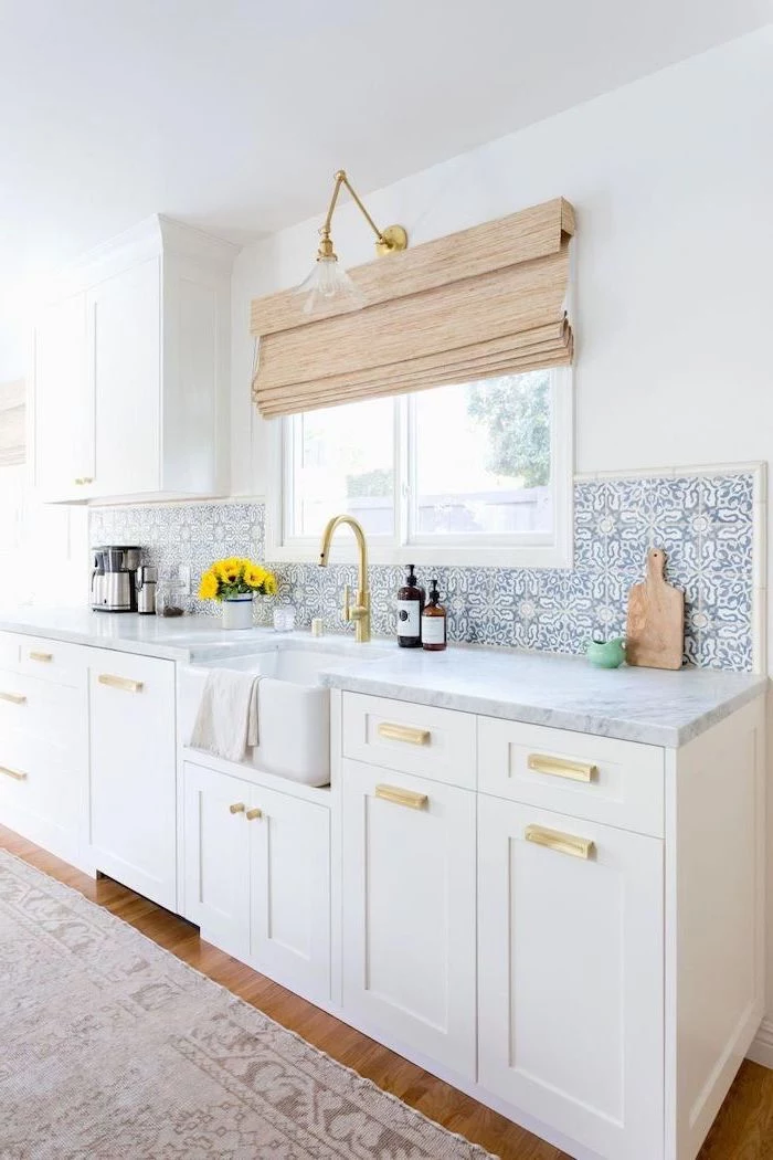 blue and white patterned tiles above the sink backsplash tile ideas white cabinets with marble countertops wooden floor