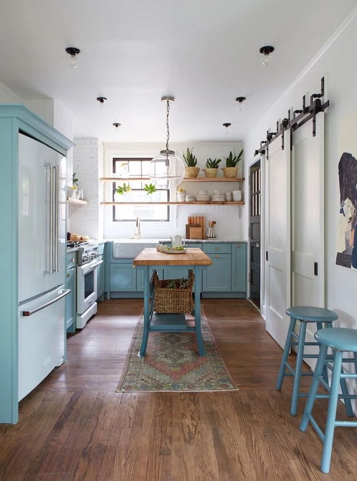 blue cabinets and kitchen island with wooden countertop farmhouse kitchen decor ideas dark wooden floor white brick walls