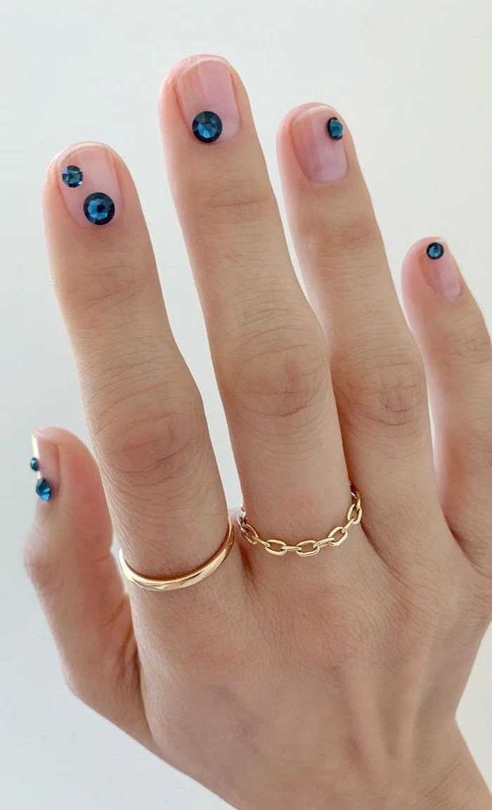 blue rhinestones in different sizes on each finger nail ideas 2020 transperant nail polish gold rings on the fingers