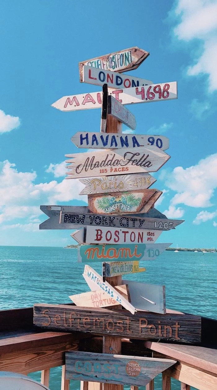 blue sky with clouds above an ocean in the background cute vsco wallpapers lots of signs pointing to different destinations
