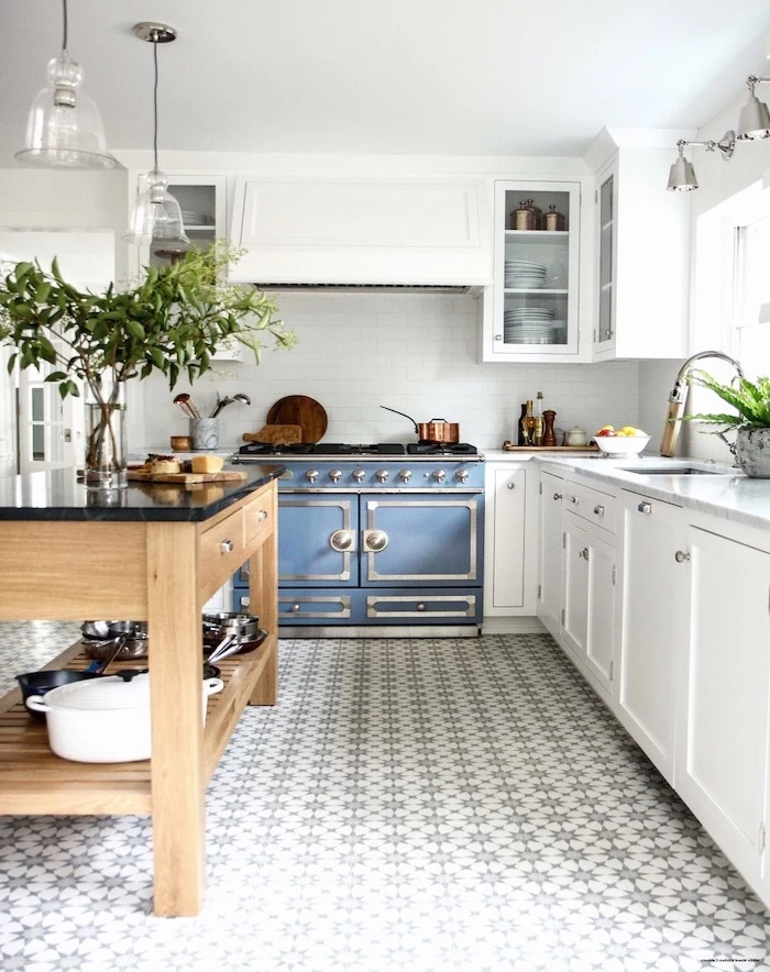 blue stove farmhouse white kitchen cabinets wooden kitchen island with open shelves black countertop black and white patterned tiled floor