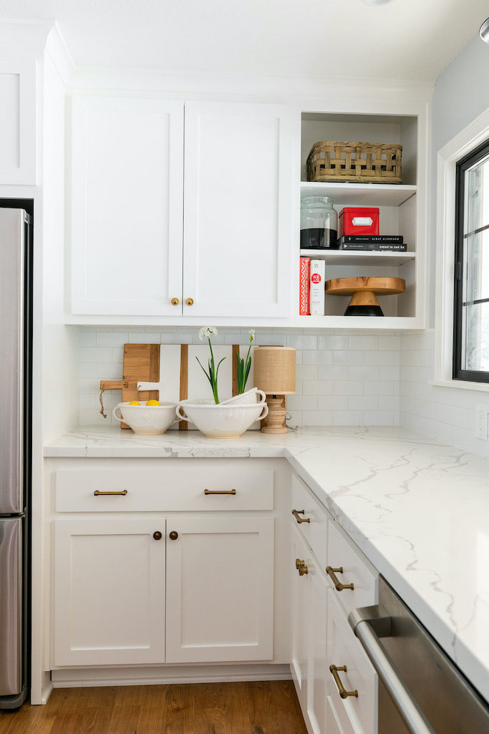 bowls full of fruit on marble countertop on white cabinets white farmhouse kitchen dark wooden floor