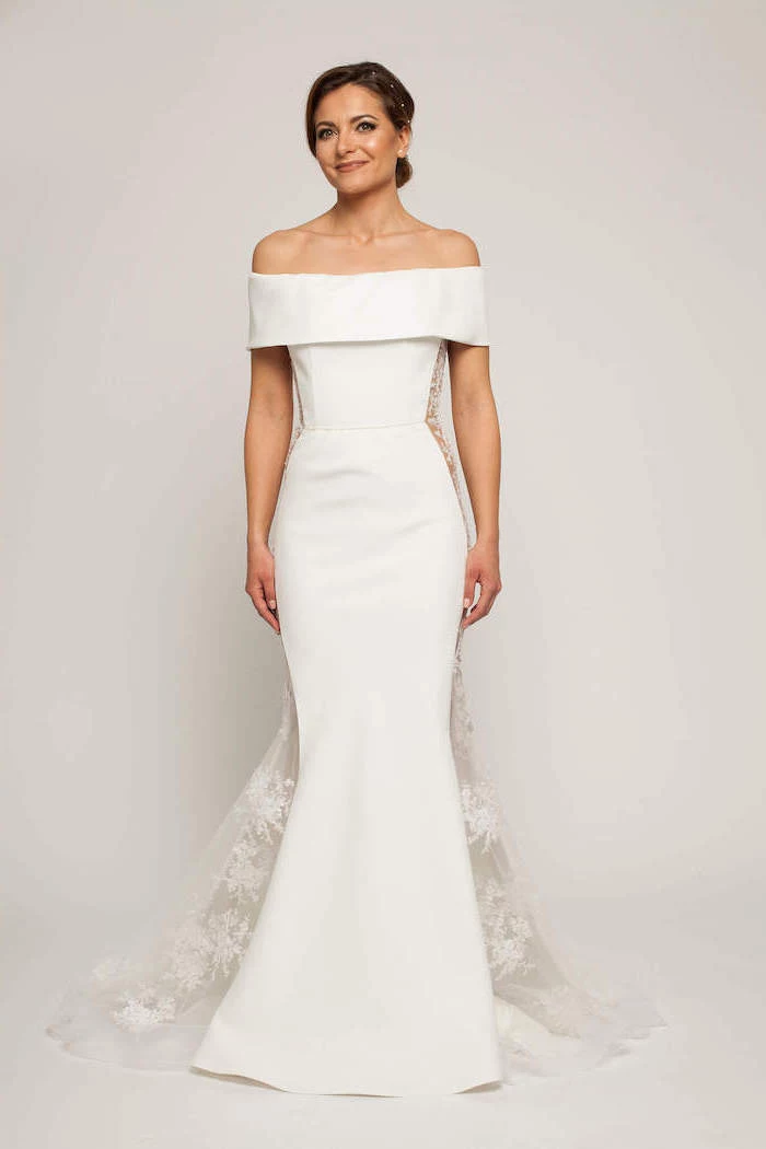 brunette woman wearing white dress off the shoulder long sleeve wedding dress lace on the sides of the dress and lace train