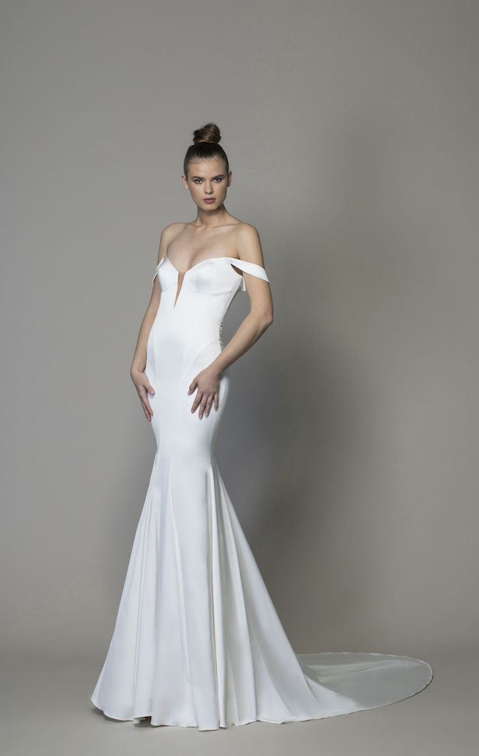 brunette woman with hair in a bun wearing satin dress with long train beaded wedding dresses