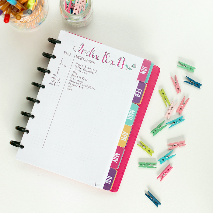 bullet journal index with page numbers written in pink on white notebook bullet journal monthly spread colorful pins on the side