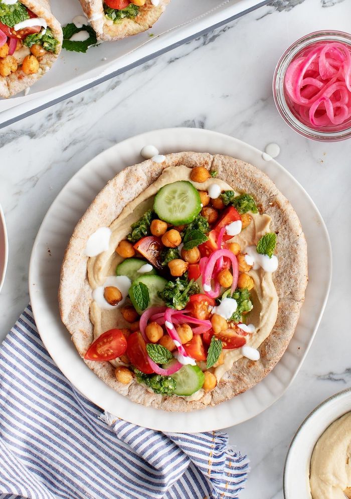chickpea shawarma canned chickpea recipes hummus cucumbers tomatoes onion mint leaves yoghurt dressing inside placed on white plate