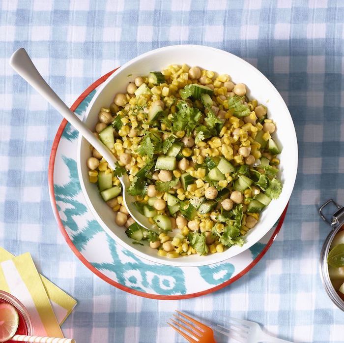 corn and chickpea salad with cucumbers how to cook chickpeas garnished with parsley inside white ceramic bowl with spoon on the side