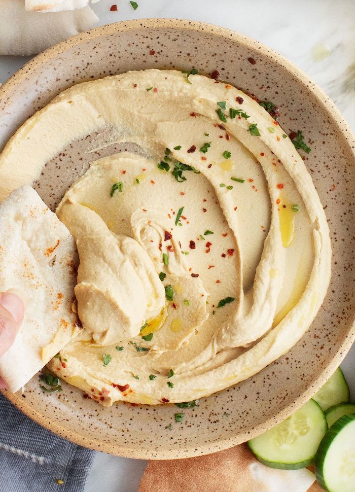 creamy hummus inside ceramic bowl garnished with herbs roasted chickpeas snack pita bread for the hummus