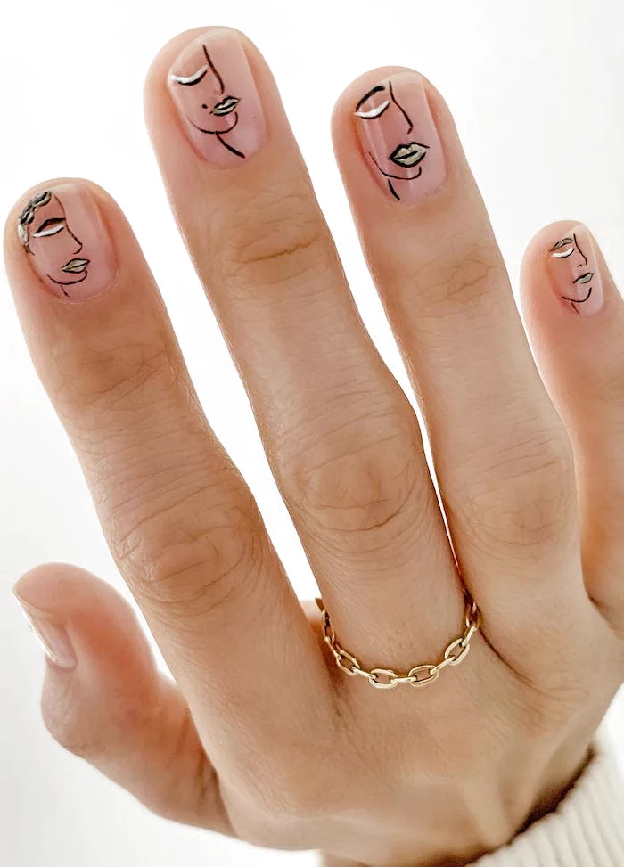 cute acrylic nails short squoval nails female face silhouettes drawn on them in black white gold with transperent nail polish