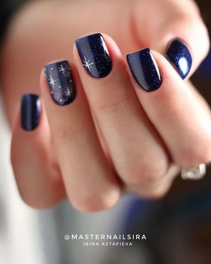 dark blue glitter nail polish on medium length square nails decorations with white stars fall nail designs