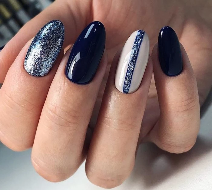 dark blue nail polish blue glitter on index finger white nail polish on ring finger cute acrylic nails almond nails