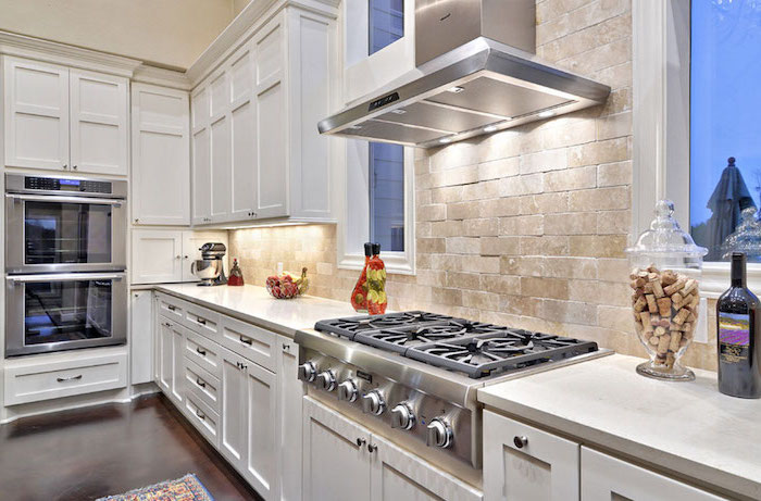 dark wooden floor white cabinets with white countertops subway tile backsplash white bricks for backsplash