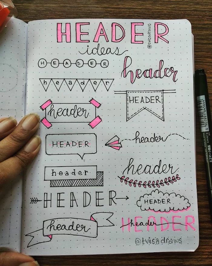 different types of header written in different styles on white notebook what is a bullet journal placed on wooden surface