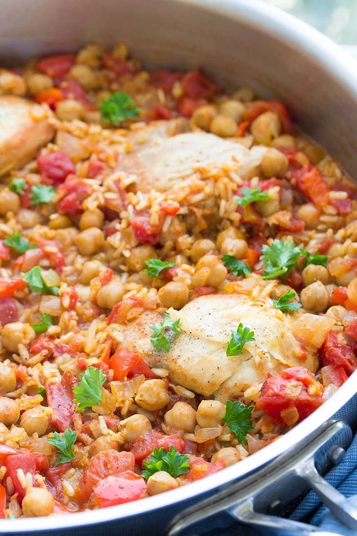 easy chickpea recipes with tomatoes rice and chicken fillet cooked inside a skillet garnished with chopped parsley